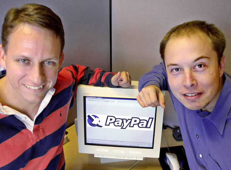 Elon Musk junto a un monitor de ordenador con el logo de PayPal